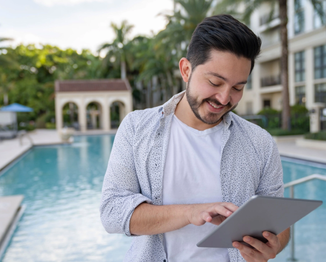 Man using tablet by the pool