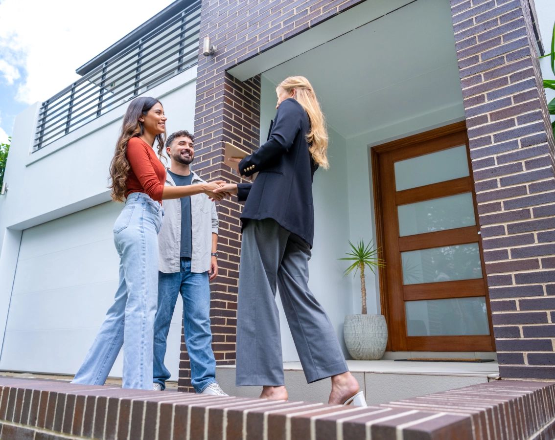 Couple shaking hands with real estate agent